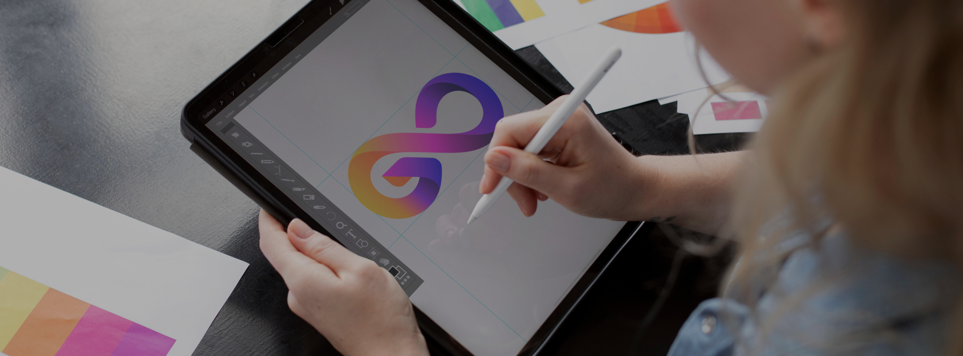 Foto ilustrativa de uma designer criando um logotipo em um tablet